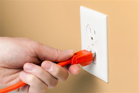 plug in with hand - Electrical cord is being plugged into a wall outlet Stock Photo - Budget Royalty-Free & Subscription, Code: 400-06527657