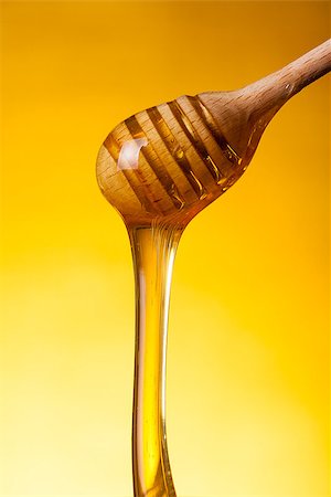 simsearch:400-06640106,k - Close-up shot of wooden drizzler and flowing honey over yellow background Stock Photo - Budget Royalty-Free & Subscription, Code: 400-06529339