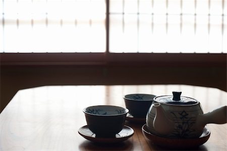 A silhouette image of two japanese tea cups and a tea pot with a defocused paper screen window to the rear Foto de stock - Super Valor sin royalties y Suscripción, Código: 400-06521357