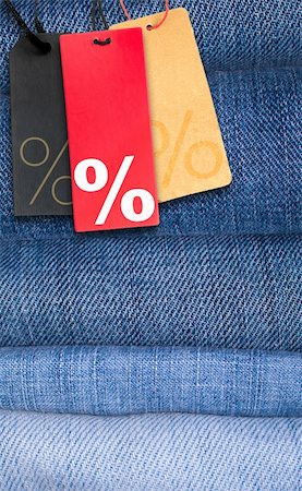 reduced sign in a shop - Sale Tags With Percentage Symbol on Stack of Blue Jeans Stock Photo - Budget Royalty-Free & Subscription, Code: 400-06521519