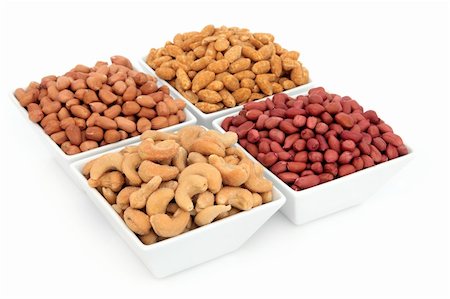 Peanut, redskin, roasted and cashew nuts in porcelain bowls over white background. Stock Photo - Budget Royalty-Free & Subscription, Code: 400-06522205