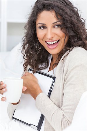 simsearch:400-07112758,k - Beautiful young Latina Hispanic woman laughing, relaxing, using a tablet computer and drinking tea or coffee Fotografie stock - Microstock e Abbonamento, Codice: 400-06530158