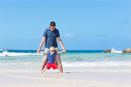 handsome little kid and his father standing barefoot at the tropical beach Stock Photo - Budget Royalty-Free & Subscription, Code: 400-06530645