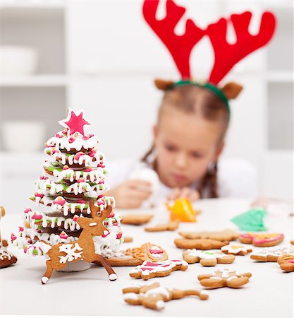 Christmas kids dressed as reindeer  decorating gingerbread cookies - focus on foreground Photographie de stock - Aubaine LD & Abonnement, Code: 400-06555475