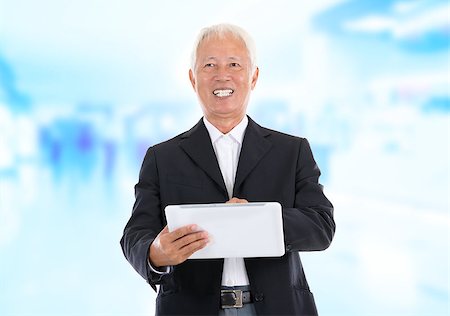 simsearch:400-07515329,k - Asian senior businessman using tablet-pc standing office background Stock Photo - Budget Royalty-Free & Subscription, Code: 400-06555843