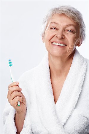 simsearch:400-06482471,k - Elderly woman with a toothbrush on white background Stock Photo - Budget Royalty-Free & Subscription, Code: 400-06556015