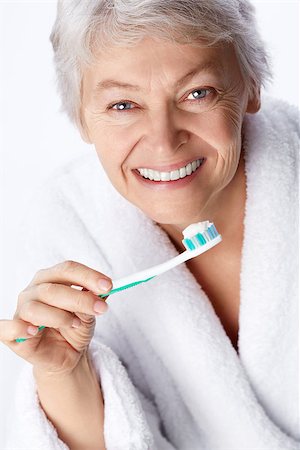 simsearch:400-06482471,k - Elderly woman with a toothbrush on white background Stock Photo - Budget Royalty-Free & Subscription, Code: 400-06556016