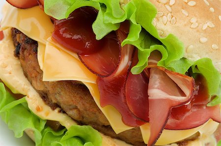 simsearch:400-06330800,k - Tasty Hamburger with Beef, Bacon, Cheese, Tomato, Lettuce,  Cheese Sauce and Ketchup on Sesame Seed Bun closeup Stock Photo - Budget Royalty-Free & Subscription, Code: 400-06556410