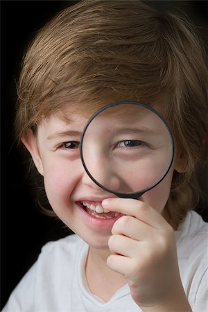 simsearch:400-06744095,k - Cute little boy looking through a magnifying glass and smiling Stock Photo - Budget Royalty-Free & Subscription, Code: 400-06557347