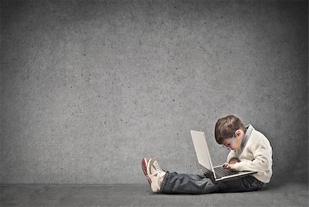 small business computers - Child concentrated on a laptop in a dark room Photographie de stock - Aubaine LD & Abonnement, Code: 400-06557513