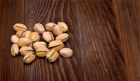 simsearch:400-06556120,k - Roasted pistachios on natural wooden table background Fotografie stock - Microstock e Abbonamento, Codice: 400-06557679