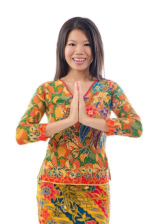 Southeast Asian female in a traditional greeting gesture, isolated white background Stock Photo - Budget Royalty-Free & Subscription, Code: 400-06558393