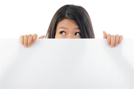 simsearch:400-05718227,k - Southeast Asian woman eyes opened big looking side holding a placard, hiding behind and covering mouth. Stock Photo - Budget Royalty-Free & Subscription, Code: 400-06558406