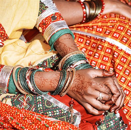 Hands of a young Indian woman adorned with traditional bangles and mehndi. Mehandi, also known as henna is a temporary form of skin decoration in India. Stock Photo - Budget Royalty-Free & Subscription, Code: 400-06558559