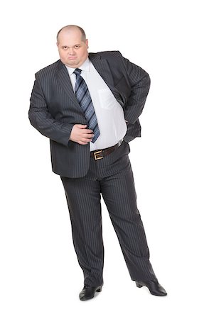 fat belly man - Fat overweight businessman in a stylish suit standing with his hand on his hip glowering at the camera with a displeased expression, studio portrait on white Stock Photo - Budget Royalty-Free & Subscription, Code: 400-06558812