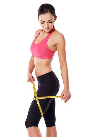 Shapely fit woman athlete measuring her thigh with a tape measure to keep watch on her weight gain or loss Stock Photo - Budget Royalty-Free & Subscription, Code: 400-06559947