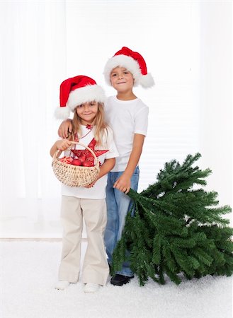 Kids wearing santa hats preparing to decorate the christmas tree - getting the props together Photographie de stock - Aubaine LD & Abonnement, Code: 400-06553843