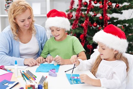 Family around christmas time making greeting cards wearing santa hats Stock Photo - Budget Royalty-Free & Subscription, Code: 400-06553901