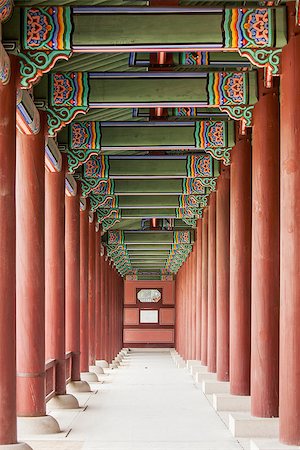 A colonnade at the Geunjeongmun Gate (or third gate) of the Gyeongbokgung Palace complex in Seoul, Korea shows the row of red columns topped by ornately painted wood beams. Foto de stock - Super Valor sin royalties y Suscripción, Código: 400-06564783