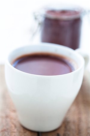 simsearch:400-08338402,k - Closeup of cup of hot chocolate on a wooden table with cocoa powder in glass jar in background Foto de stock - Super Valor sin royalties y Suscripción, Código: 400-06565008