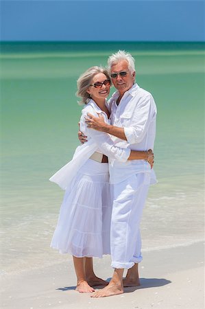 Happy senior man and woman couple together embracing by sea on a deserted tropical beach with bright clear blue sky Stock Photo - Budget Royalty-Free & Subscription, Code: 400-06566223