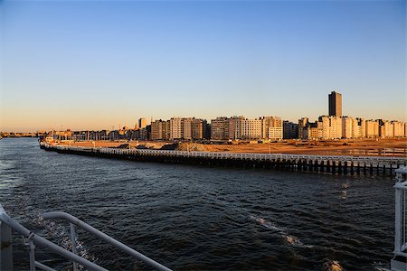 Coastline of Ostend city in the rays of the sunset as seen from the deck of a ferry departs Stock Photo - Budget Royalty-Free & Subscription, Code: 400-06566794