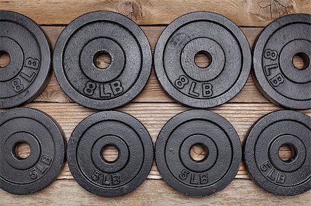simsearch:400-07620929,k - background of exercise weights -  iron dumbbell plates on a wooden deck Stock Photo - Budget Royalty-Free & Subscription, Code: 400-06566861