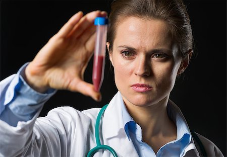 simsearch:400-07099889,k - Medical doctor woman looking on test tube with blood isolated on black Stock Photo - Budget Royalty-Free & Subscription, Code: 400-06567011