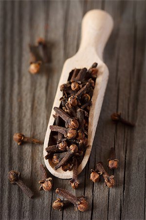 simsearch:400-04298290,k - Spicy cloves in a wooden scoop on an old board. Fotografie stock - Microstock e Abbonamento, Codice: 400-06568905