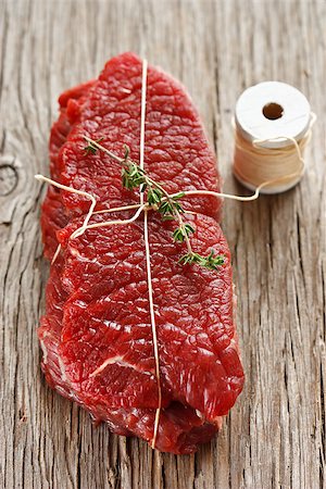 Raw beef meat  witn thyme  on an old kitchen board. Stock Photo - Budget Royalty-Free & Subscription, Code: 400-06568907