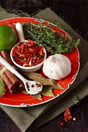 simsearch:400-06365740,k - Spices and herbs in a rustic plate on an old wooden board. Stockbilder - Microstock & Abonnement, Bildnummer: 400-06568901
