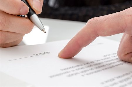 divórcio - Detail of a woman signing a paper. Male finger showing where to sign. Foto de stock - Royalty-Free Super Valor e Assinatura, Número: 400-06569954