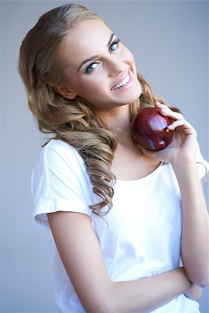 Head shot of woman holding red apple against grey background Stock Photo - Budget Royalty-Free & Subscription, Code: 400-06560056