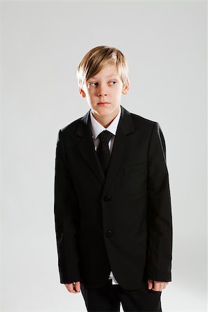 Studio portrait of serious looking young boy wearing black suit Stock Photo - Budget Royalty-Free & Subscription, Code: 400-06560127