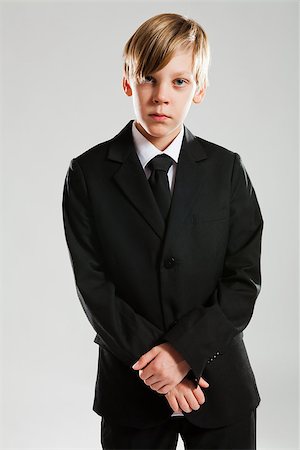 Studio portrait of serious looking young boy wearing black suit Stock Photo - Budget Royalty-Free & Subscription, Code: 400-06560134