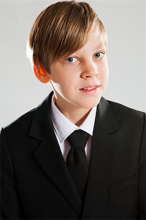 Studio portrait of a happy smiling young boy wearing black suit Stock Photo - Budget Royalty-Free & Subscription, Code: 400-06560135