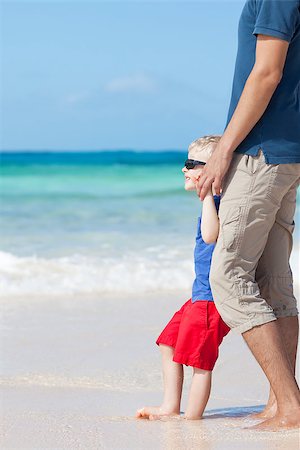 little kid barefoot at the perfect beach together with his father Stock Photo - Budget Royalty-Free & Subscription, Code: 400-06561089
