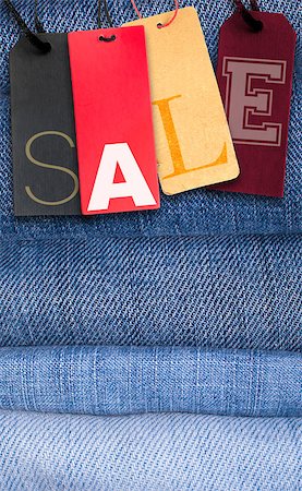 reduced sign in a shop - Paper Tags With Sale Sign on Stack of Blue Jeans Stock Photo - Budget Royalty-Free & Subscription, Code: 400-06561262