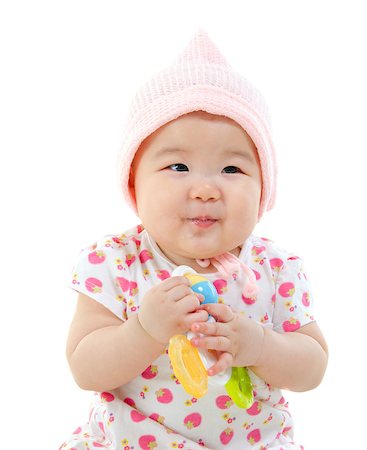 simsearch:400-07173561,k - Asian baby girl in pink dress gripping a toy sitting on white background Foto de stock - Royalty-Free Super Valor e Assinatura, Número: 400-06561606