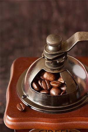 simsearch:400-07981187,k - Old-fashioned handle coffee grinder with coffee beans on a dark wooden background close-up. Foto de stock - Royalty-Free Super Valor e Assinatura, Número: 400-06561684