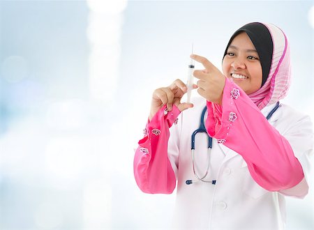 Muslim female medical doctor filling the syringe getting ready for a medical procedure, hospital blue background Stock Photo - Budget Royalty-Free & Subscription, Code: 400-06561700