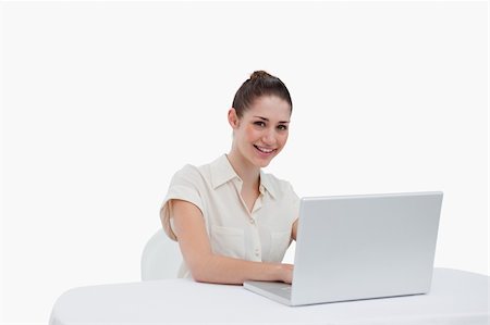 simsearch:400-08554629,k - Smiling businesswoman using a notebook against a white background Fotografie stock - Microstock e Abbonamento, Codice: 400-06626994