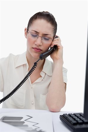 phone with pain - Portrait of a young manager making a phone call while looking at statistics against a white background Stock Photo - Budget Royalty-Free & Subscription, Code: 400-06627026