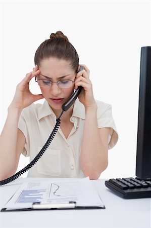 phone with pain - Portrait of a sad manager making a phone call while looking at statistics against a white background Stock Photo - Budget Royalty-Free & Subscription, Code: 400-06627027