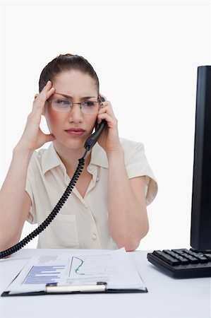 phone with pain - Portrait of a worried manager making a phone call while looking at statistics against a white background Stock Photo - Budget Royalty-Free & Subscription, Code: 400-06627028