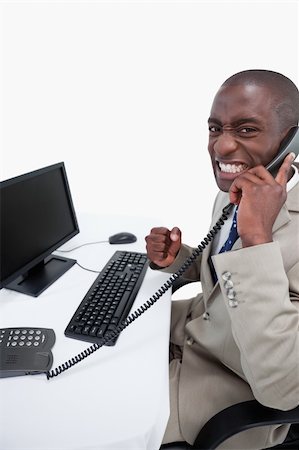 Side view of a businessman answering the phone while using a monitor against a white background Foto de stock - Super Valor sin royalties y Suscripción, Código: 400-06627042