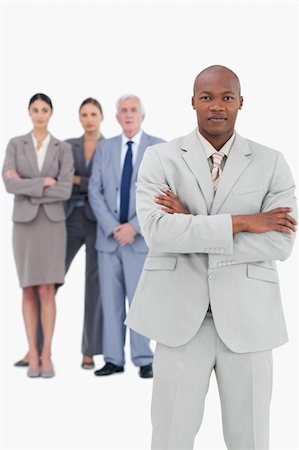 simsearch:400-07186359,k - Businessman with folded arms and team behind him against a white background Photographie de stock - Aubaine LD & Abonnement, Code: 400-06627197