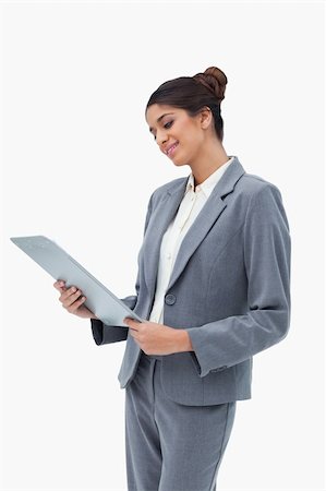 simsearch:400-06633122,k - Smiling businesswoman looking at clipboard against a white background Stock Photo - Budget Royalty-Free & Subscription, Code: 400-06627230