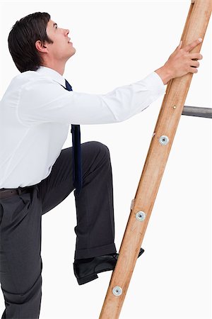 Side view of young tradesman climbing a ladder against a white background Stock Photo - Budget Royalty-Free & Subscription, Code: 400-06634224