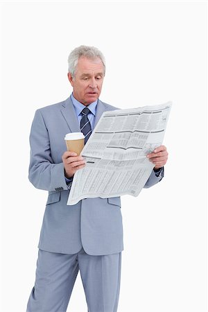 Mature tradesman with paper cup reading news paper against a white background Stock Photo - Budget Royalty-Free & Subscription, Code: 400-06634319